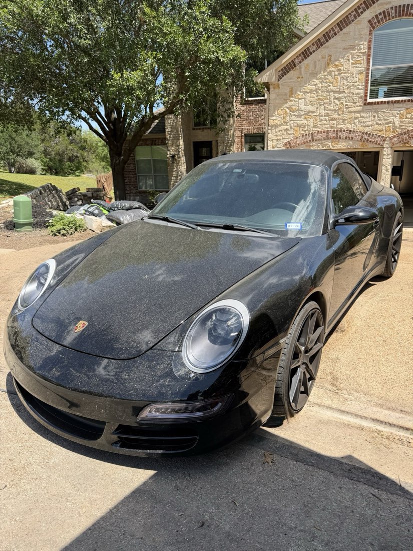 Porsche 911 before detailing, showing road grime and water spotting